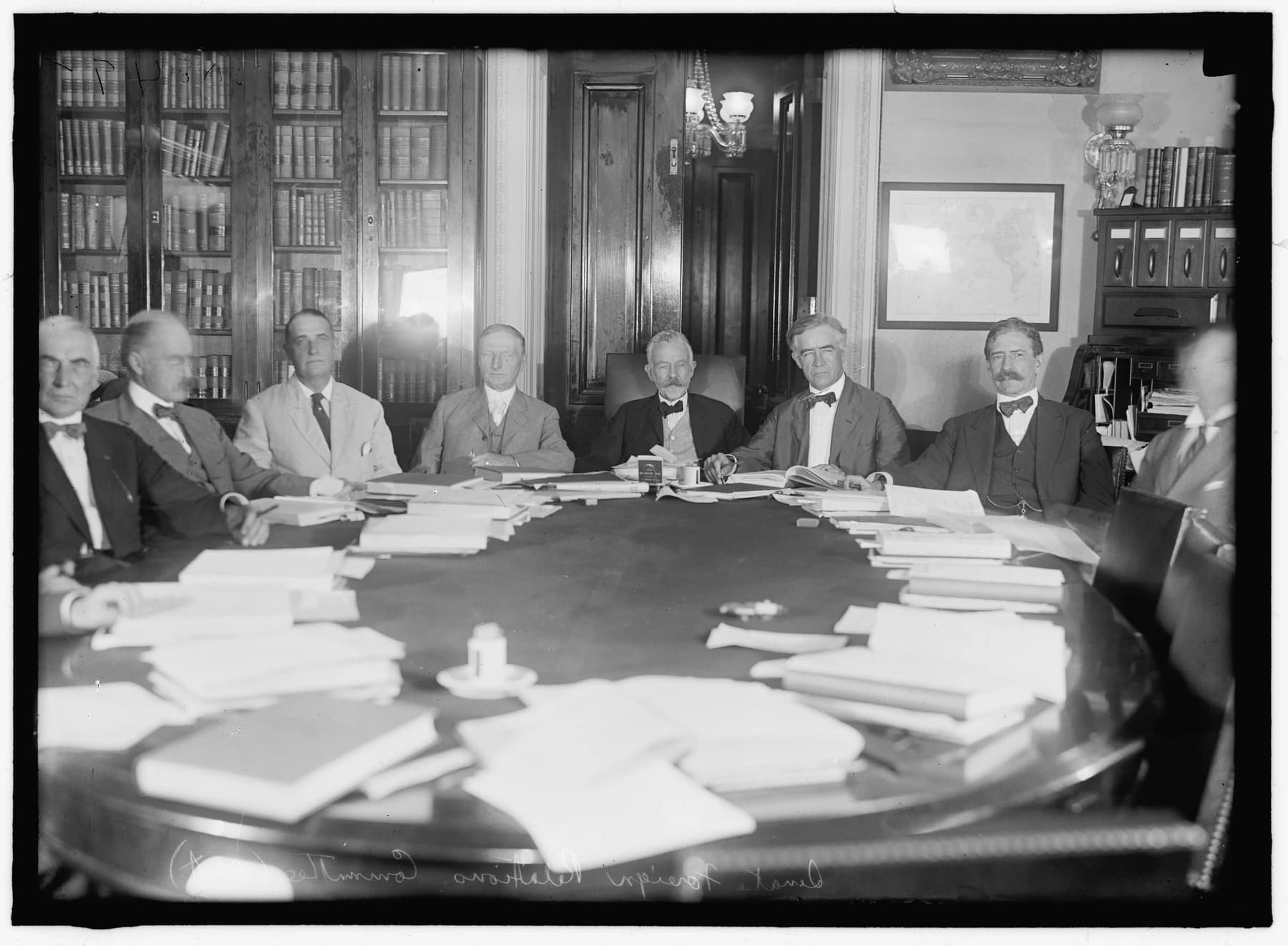 Members of the Senate Foreign Relations Committee gathered around a table covered with papers in 1919.